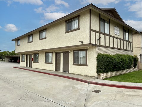 A two-story building with a beige facade and dark brown trim.