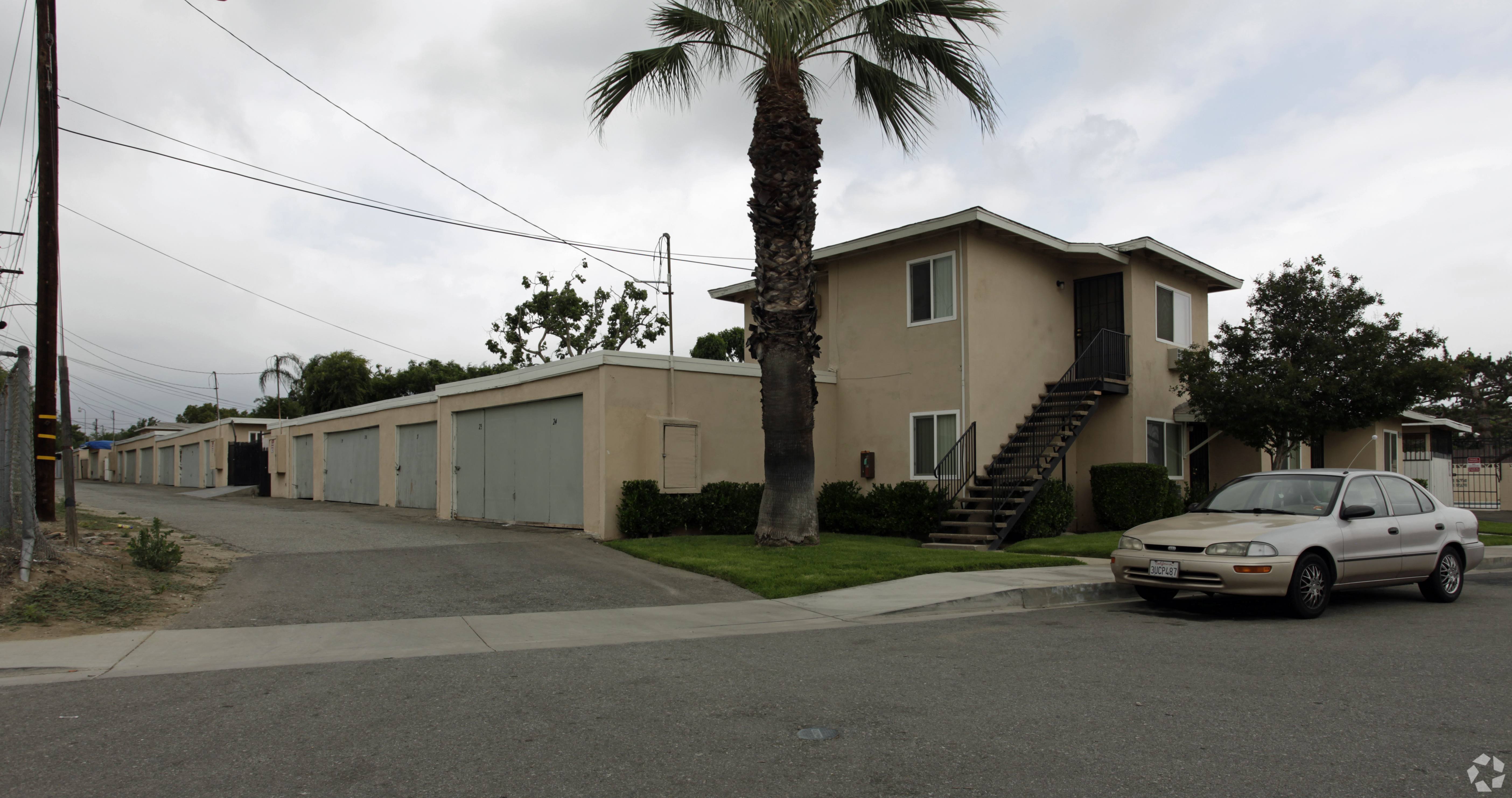 A white car is parked in front of a house.