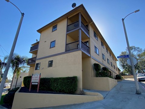A yellow building with a balcony on the second floor.