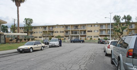 A parking lot with cars and apartment buildings in the background.