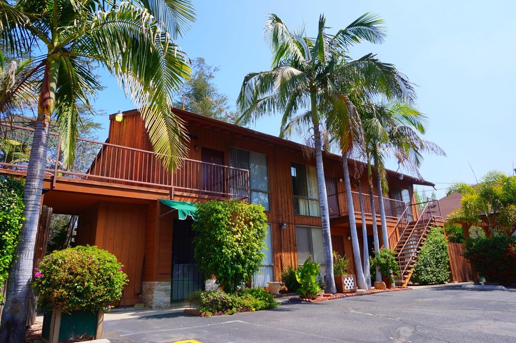 A large wooden building with a balcony and a staircase.