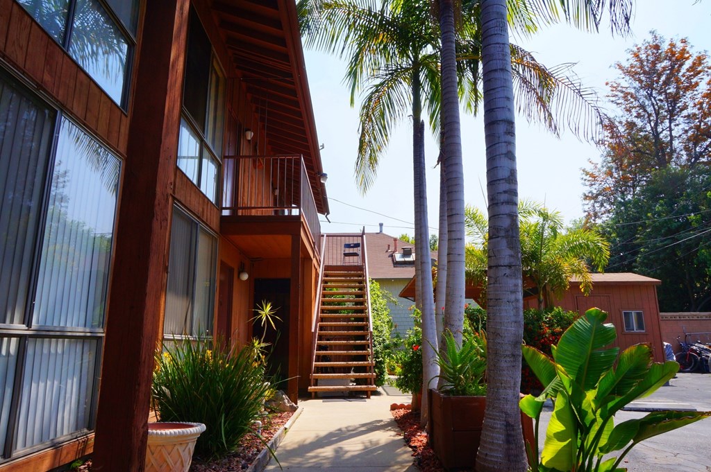A wooden house with a staircase leading to the second floor.