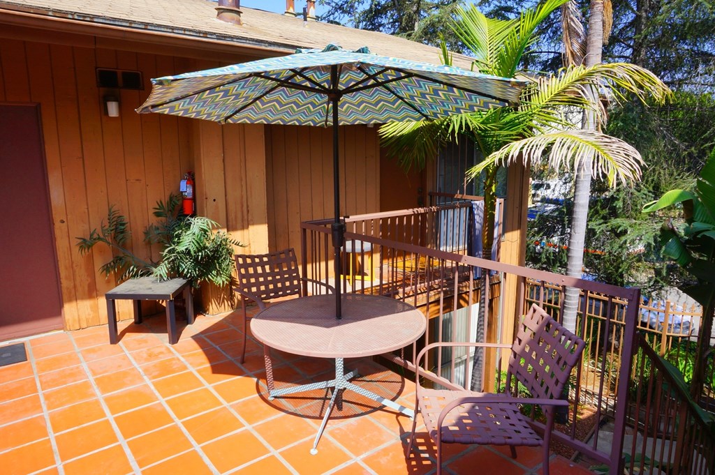 A patio with a table and chairs under an umbrella.