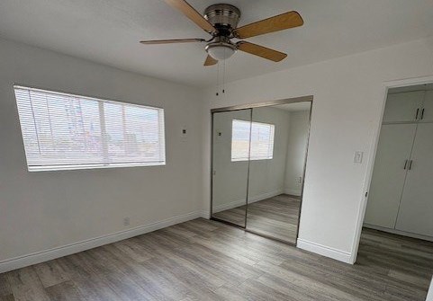 A room with a ceiling fan and a large mirror.