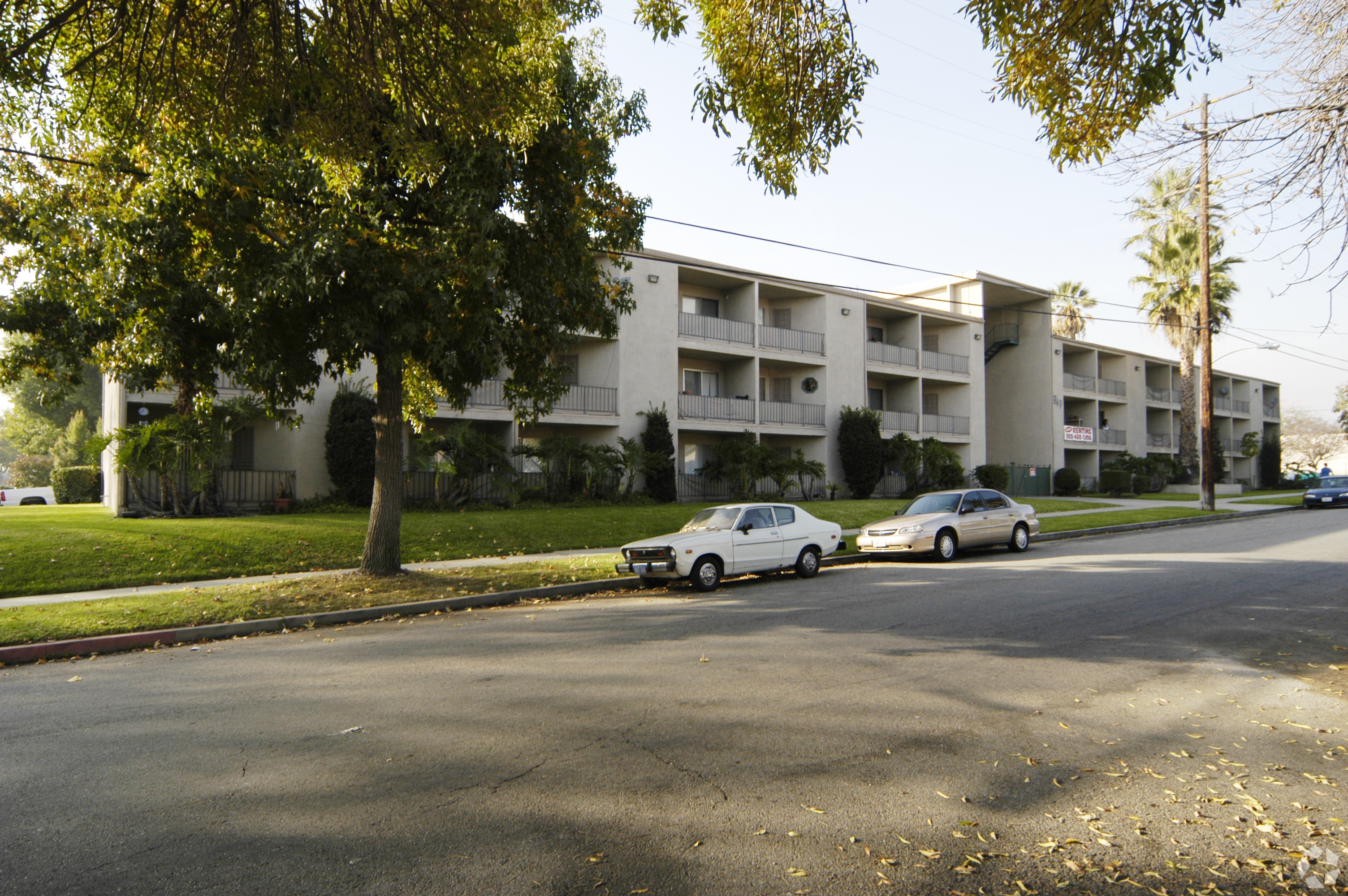 Apartment building with cars parked in front.