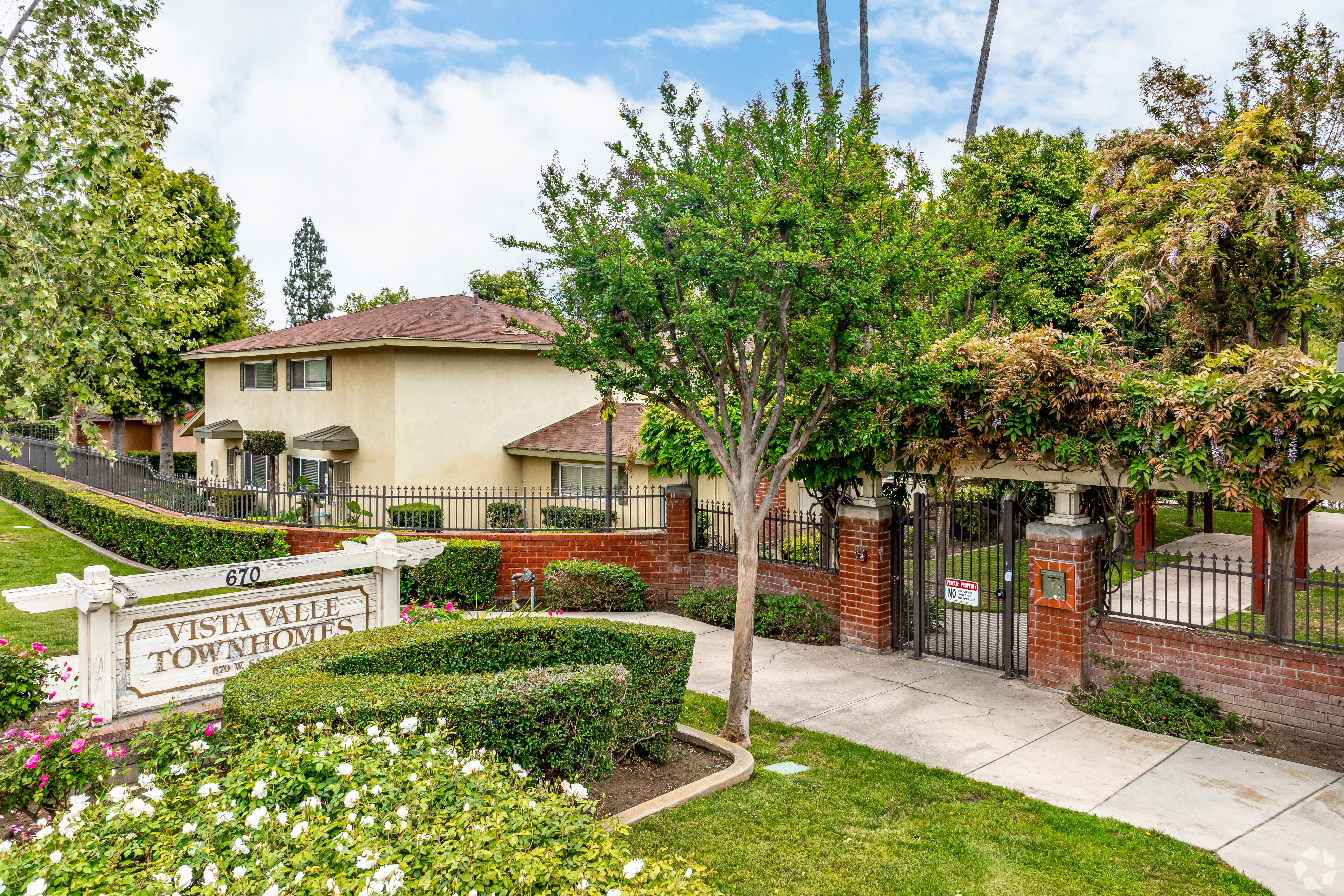 A sign that says Vista Valley Townhouses in front of a house.