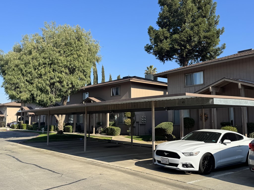 A white car is parked in front of a building.