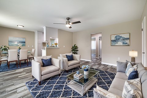 A living room with a grey couch, a coffee table, and a painting on the wall.