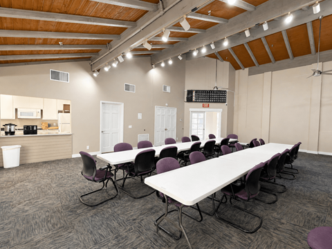 A conference room with a long table and chairs.