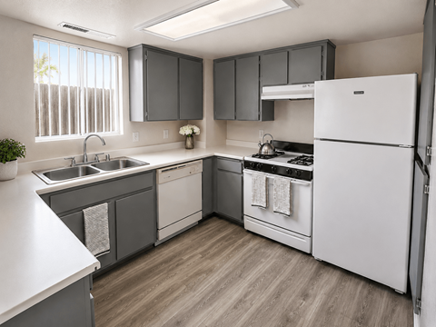 A kitchen with a white refrigerator, a sink, and a stove.