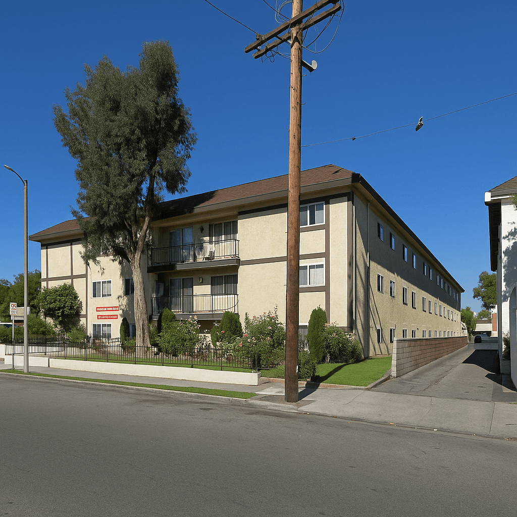 A tree in front of a building with a clear blue sky.