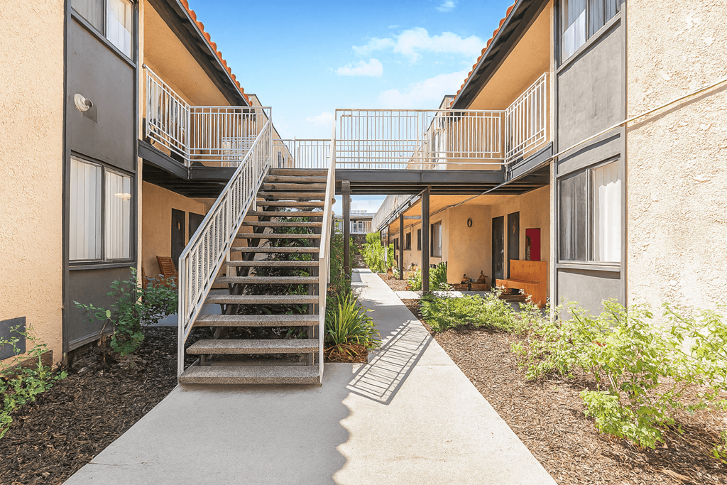 A staircase with a metal railing leads to a balcony.