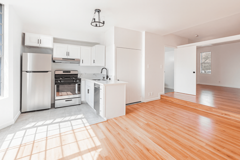A kitchen with wooden floors and white walls.