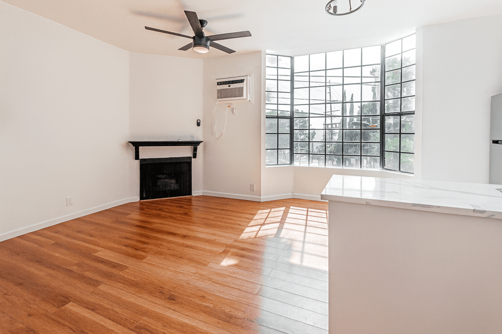 A room with a fireplace and a ceiling fan.