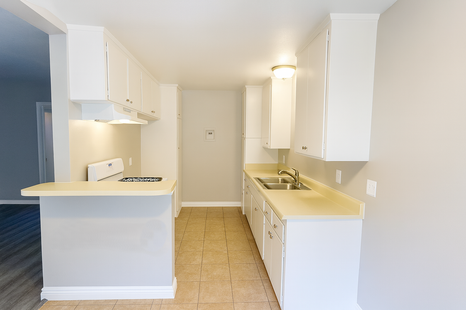 A kitchen with white cabinets and a white island.