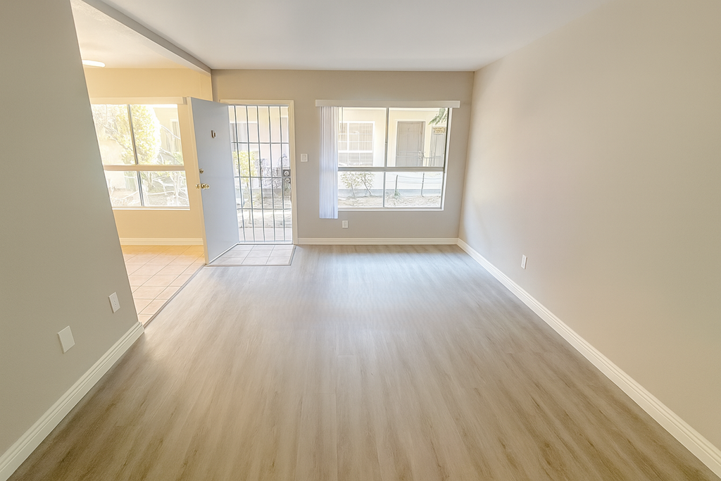 A room with light wood flooring and white walls.
