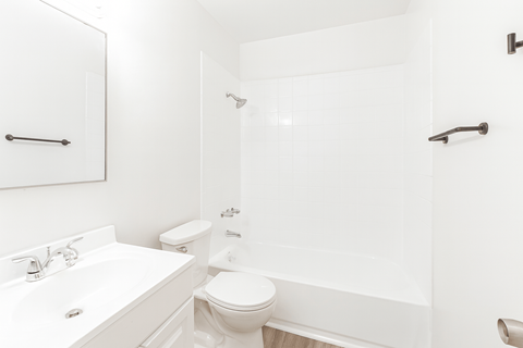 A white bathroom with a toilet, sink, and bathtub.