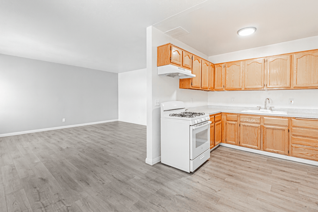 A white stove and oven in a kitchen with wooden cabinets.
