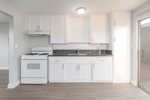 A white kitchen with a stove and cabinets.