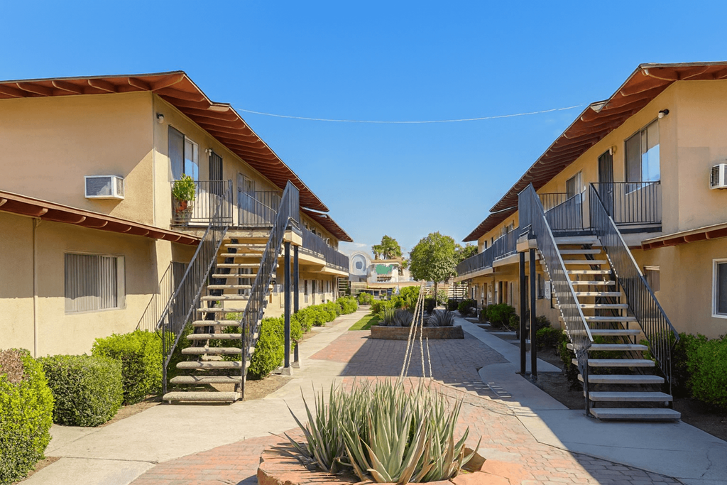 A sunny day at a residential area with houses and staircases leading to the front doors.