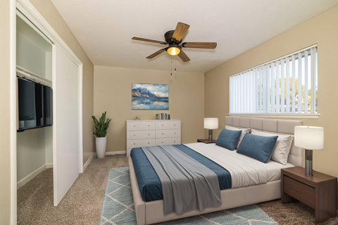 A bedroom with a bed, nightstand, and a ceiling fan.