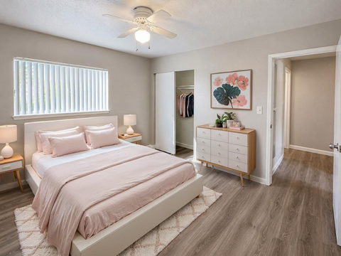 A bedroom with a large bed and a dresser with a mirror.