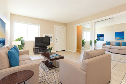 A living room with a beige couch, a coffee table, and a television.