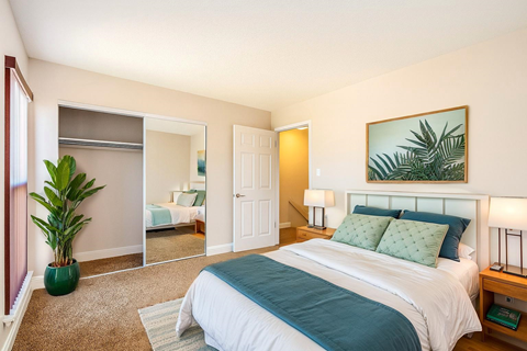 A bedroom with a large bed and a mirror on the wall.