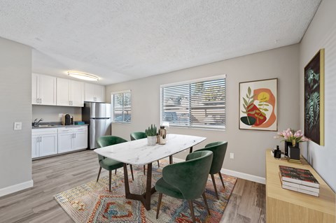 A dining room with a table and chairs.