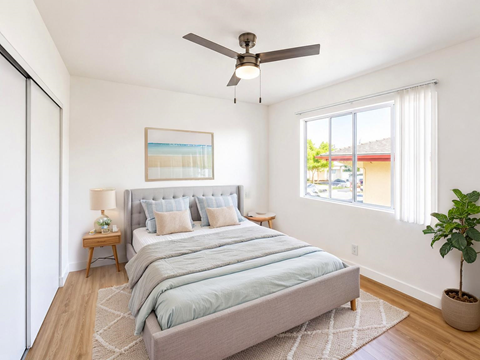 A bedroom with a large bed and a ceiling fan.