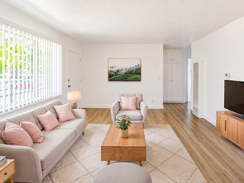 A living room with a grey couch, a coffee table, and a painting on the wall.