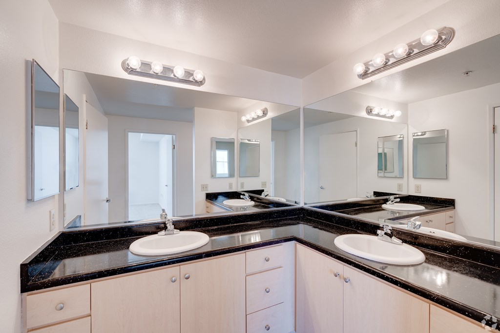 A bathroom with two sinks and a large mirror.