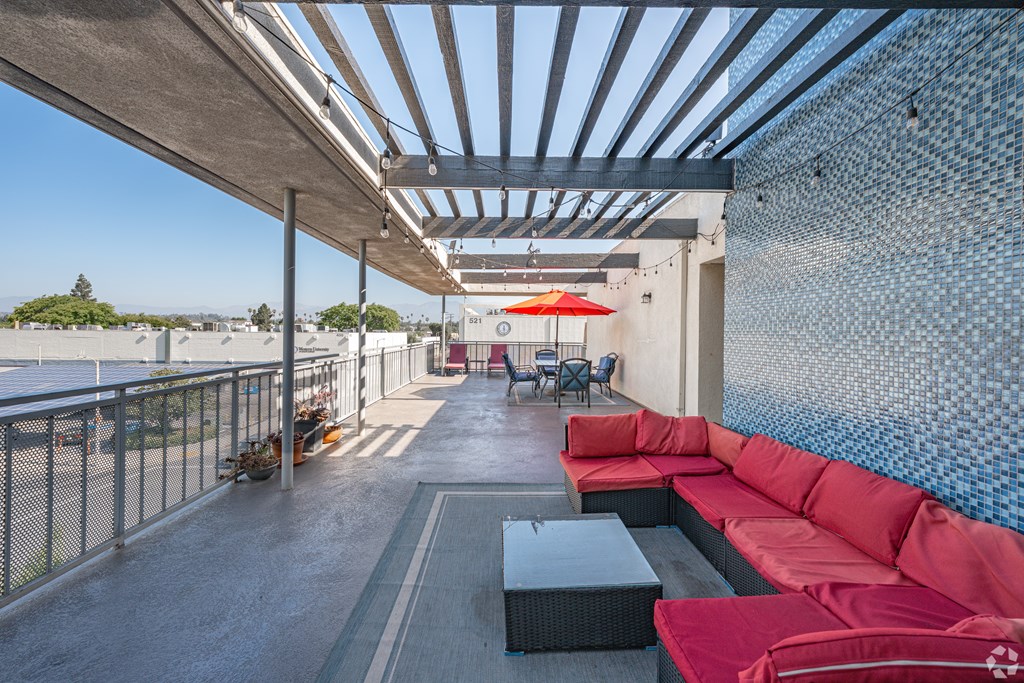 A patio with red couches and a table.