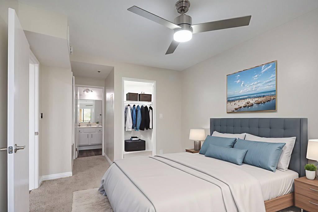 A bedroom with a large bed and a ceiling fan.