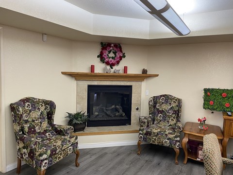 A living room with a fireplace and chairs.