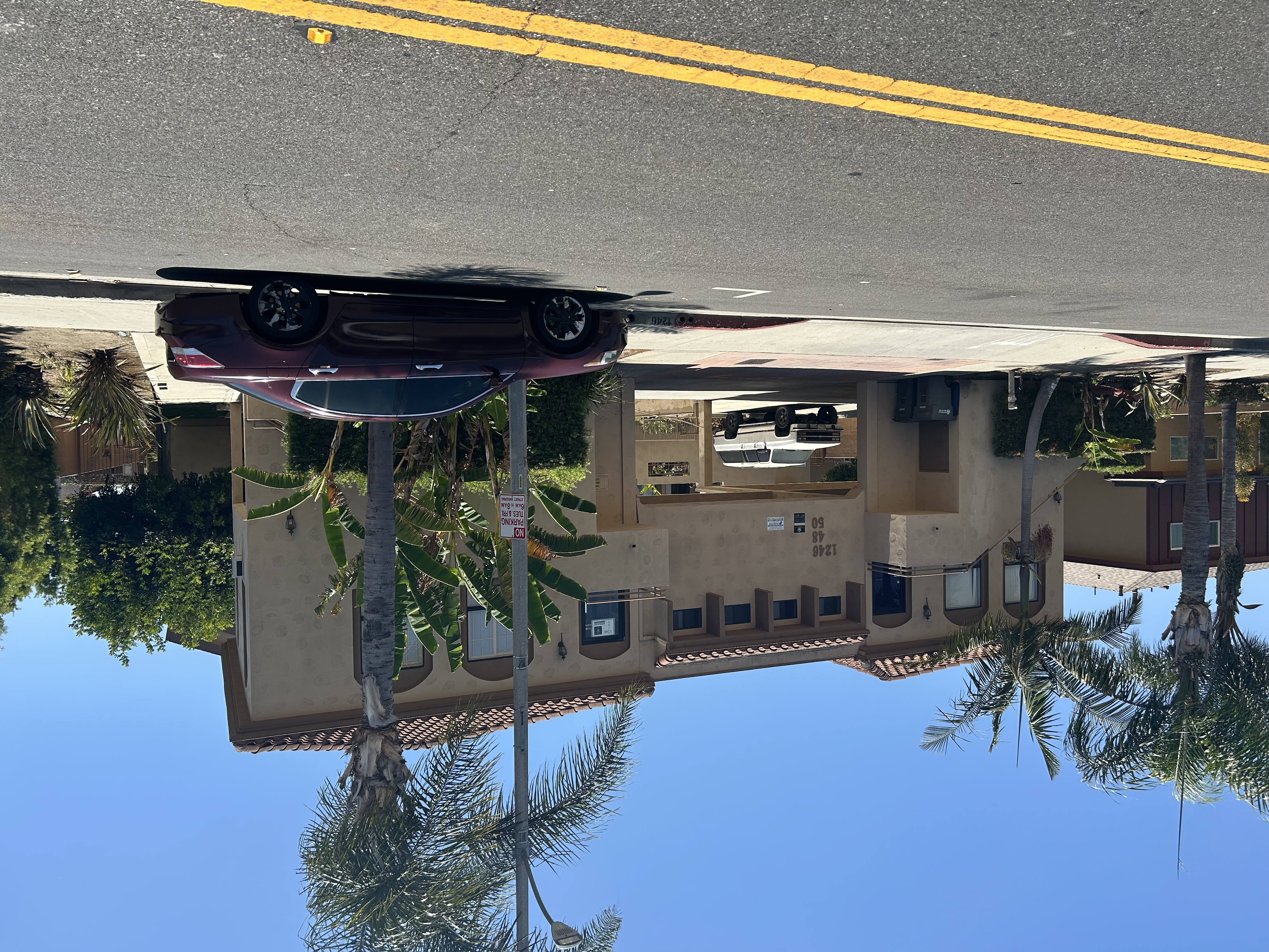A car is reflected in a puddle on the street.
