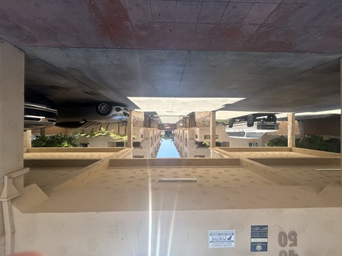 A parking garage with a concrete floor and a concrete ceiling.