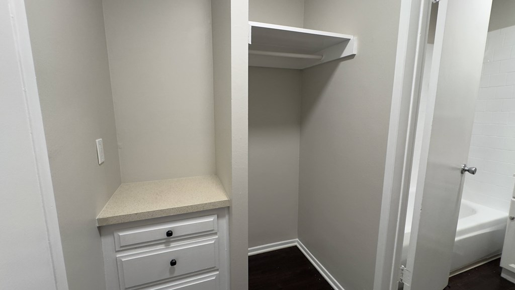 A white bathroom with a white towel rack and a white door.