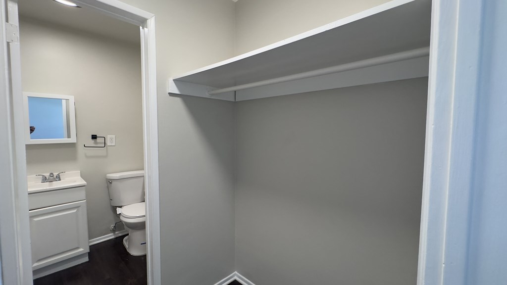 A bathroom with a toilet, sink, and a window.