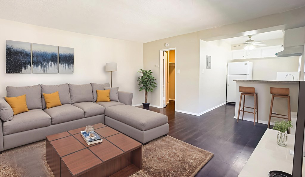 A living room with a grey couch and a brown coffee table.