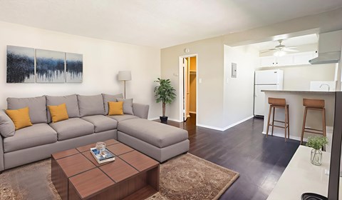 A living room with a grey couch and a brown coffee table.