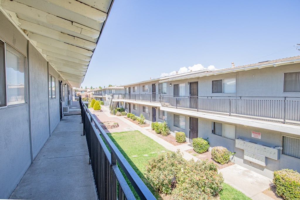 A row of houses with a green lawn in between.