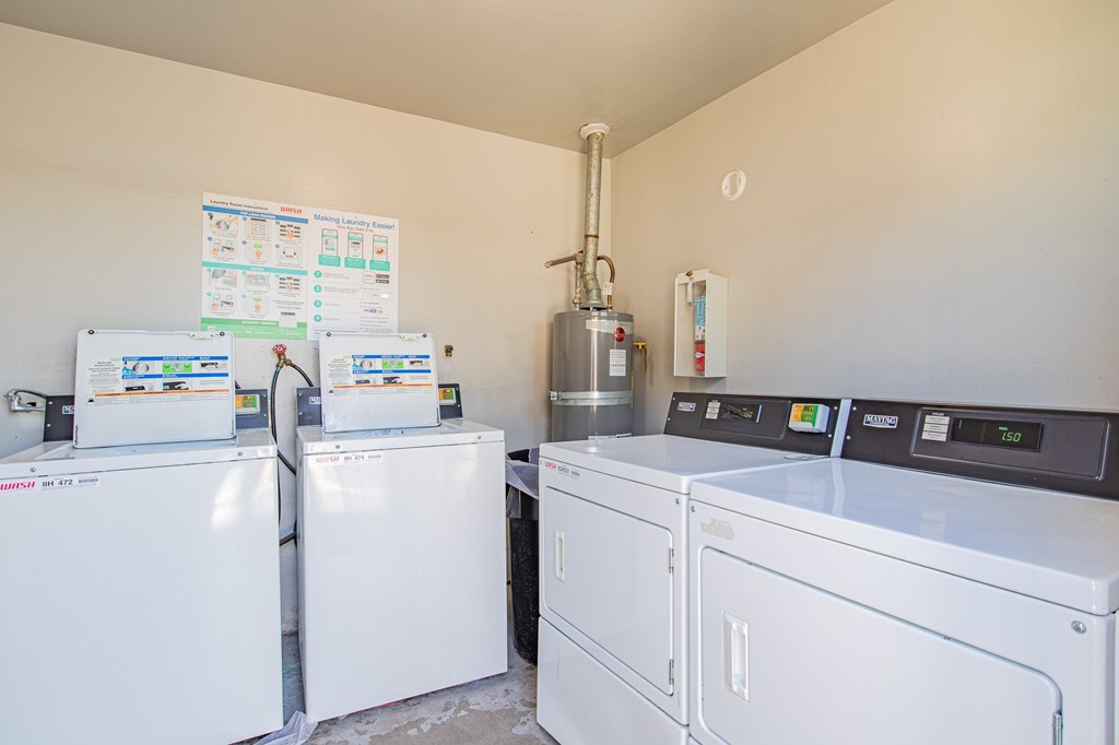 A laundry room with a washer and dryer and a sign on the wall.