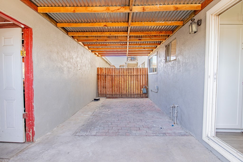 A long, narrow hallway with a wooden gate at the end.