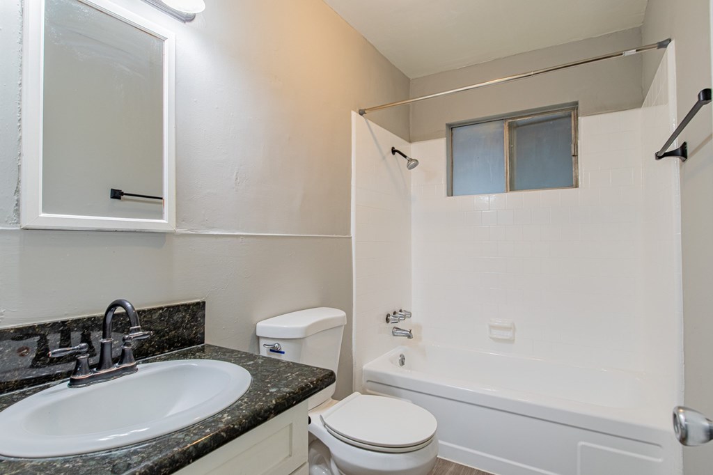 A bathroom with a toilet, sink, and bathtub.