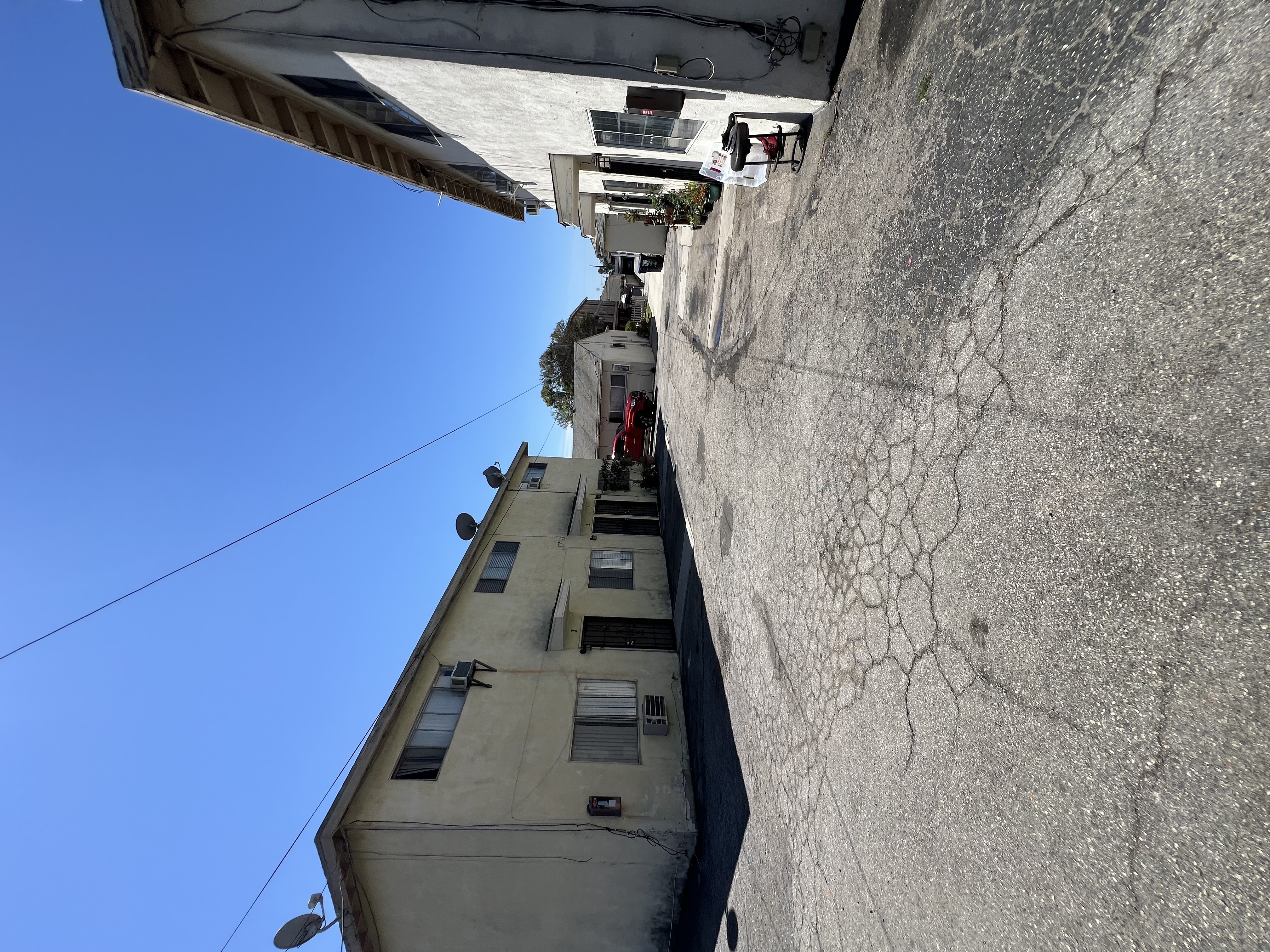 A tall building with a cracked wall and a clear blue sky.