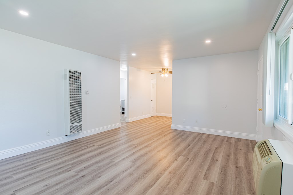 A room with wooden flooring and white walls.
