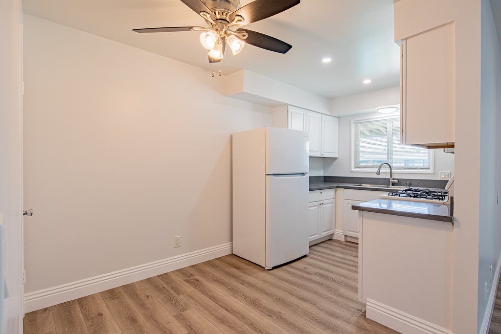 A kitchen with a refrigerator, stove, and sink.