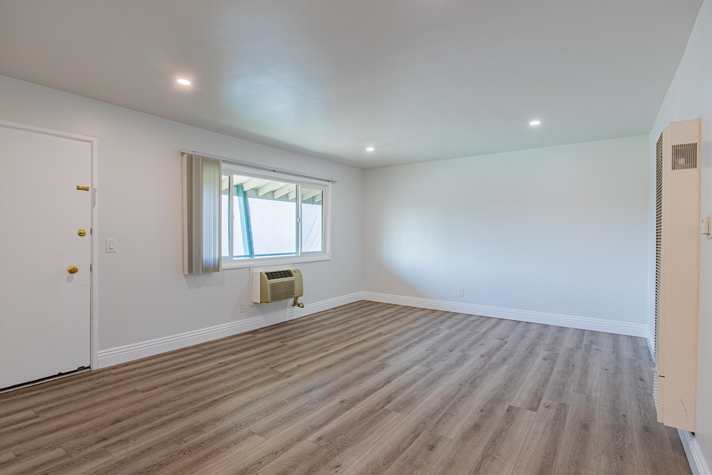 A room with a window and a radiator on the floor.