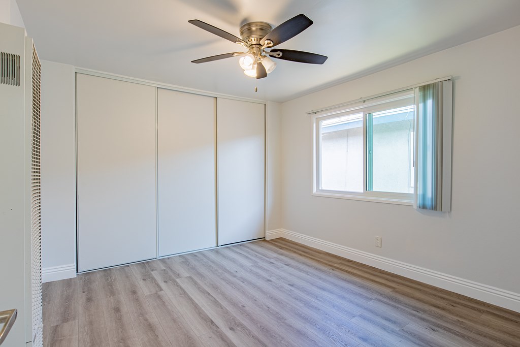 A room with a ceiling fan and a window.
